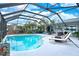 Gorgeous pool with a screened enclosure, lounge chairs, and well-maintained landscaping at 6531 Clair Shore Dr, Apollo Beach, FL 33572