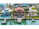 Aerial view of a waterfront home with a private pool, dock, and backyard, surrounded by palm trees at 854 Bay Point Dr, Madeira Beach, FL 33708