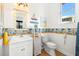 Bright, nautical themed bathroom with coastal decor, patterned wallpaper, and white vanity at 854 Bay Point Dr, Madeira Beach, FL 33708