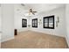 Bright bedroom with white walls, carpeted floor, three windows with shutters, and a ceiling fan at 854 Bay Point Dr, Madeira Beach, FL 33708