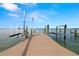 Wooden dock on the water with boat lift and American flag at 854 Bay Point Dr, Madeira Beach, FL 33708