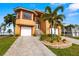 Charming two-story waterfront home with a well-manicured lawn, two-car garage, and a paver driveway at 854 Bay Point Dr, Madeira Beach, FL 33708