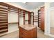 Spacious walk-in closet with custom wood shelving, drawers, and center island with marble countertop at 854 Bay Point Dr, Madeira Beach, FL 33708