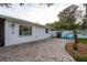 Charming back patio with paver stones, surrounded by lush landscaping, offering a serene outdoor living space at 932 Lexington Dr, Dunedin, FL 34698