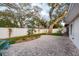 Well-maintained backyard with a paved patio, mature trees, and manicured lawn, creating a private oasis at 932 Lexington Dr, Dunedin, FL 34698