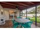 Inviting screened porch with tiled floor and outdoor dining set, ideal for enjoying fresh air and outdoor meals at 932 Lexington Dr, Dunedin, FL 34698