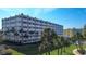 This is an exterior shot of the condominium complex surrounded by palm trees at 100 Bluff View Dr # 514A, Belleair Bluffs, FL 33770
