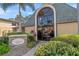 Clubhouse exterior with arched windows, brick signage, and manicured landscaping at 10221 Sailwinds S Blvd # 206, Largo, FL 33773