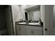 Bathroom featuring double sinks, granite countertops, white cabinets, and large mirror at 10854 Sage Canyon Dr, Riverview, FL 33578