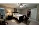Bedroom featuring a dark wood bed frame, dresser, ceiling fan, and a walk-in closet at 10854 Sage Canyon Dr, Riverview, FL 33578