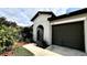 Close-up of the home's exterior, showcasing the arched entryway and landscaping at 10854 Sage Canyon Dr, Riverview, FL 33578
