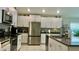 Bright kitchen featuring white cabinets, granite countertops, and stainless steel appliances at 10854 Sage Canyon Dr, Riverview, FL 33578