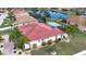 Aerial view of landscaped backyard, tiled roof, screened-in pool, and serene pond at 1115 Signature Dr, Sun City Center, FL 33573