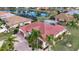A stunning aerial view shows a red-tiled roof home, lush landscaping, and a serene pond in a vibrant community at 1115 Signature Dr, Sun City Center, FL 33573