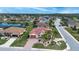 Wide aerial view of a community, showcasing a home with a red tile roof, landscaping, and a lake at 1115 Signature Dr, Sun City Center, FL 33573