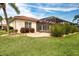 Beautifully landscaped backyard featuring a screened-in lanai and lush grass at 1115 Signature Dr, Sun City Center, FL 33573