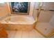 Bright bathroom featuring a marble soaking tub and glass-enclosed shower at 1115 Signature Dr, Sun City Center, FL 33573