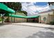 Exterior view of community center with stone facade and green awnings over the entryway and seating area at 1115 Signature Dr, Sun City Center, FL 33573