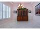 Dining room featuring white tile floors, natural light from shuttered windows, and a traditional wooden hutch at 1115 Signature Dr, Sun City Center, FL 33573