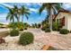 Beautiful brick driveway leads up to a home with lush landscaping featuring palm trees and manicured bushes at 1115 Signature Dr, Sun City Center, FL 33573