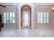 Bright foyer with neutral walls, white tile floors, and large shuttered windows for ample natural light at 1115 Signature Dr, Sun City Center, FL 33573