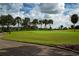 A beautiful golf course showcases lush greens, palm trees, and golfers enjoying a sunny day on the fairway at 1115 Signature Dr, Sun City Center, FL 33573