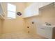 Laundry room with tiled floors, shelving, utility sink, and overhead cabinets at 1115 Signature Dr, Sun City Center, FL 33573