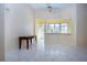 Sunlit living room with large windows, tile flooring, and a view into an adjacent room at 1115 Signature Dr, Sun City Center, FL 33573