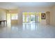 Spacious living room with tile flooring, vaulted ceilings, and abundant natural light from sliding glass doors at 1115 Signature Dr, Sun City Center, FL 33573