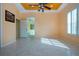 Bright living room featuring tile floors, tray ceilings, and stylish ceiling fan at 1115 Signature Dr, Sun City Center, FL 33573