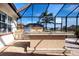 A fully equipped outdoor kitchen under a screened patio with stainless steel appliances at 1115 Signature Dr, Sun City Center, FL 33573