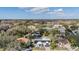 Aerial view of a home with solar panels, showcasing the backyard pond and surrounding neighborhood at 1123 Hounds Run, Safety Harbor, FL 34695