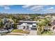 Aerial view of a home with solar panels overlooking a serene pond; a peaceful retreat at 1123 Hounds Run, Safety Harbor, FL 34695