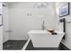 Bright bathroom featuring a soaking tub, walk-in shower, with tile surround and stone floor at 1123 Hounds Run, Safety Harbor, FL 34695
