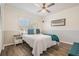 Cozy bedroom with hardwood flooring, a ceiling fan and a large window with plantation shutters at 1123 Hounds Run, Safety Harbor, FL 34695