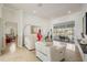 Elegant living room with tile floors, white recliner seating and backyard pool view at 1123 Hounds Run, Safety Harbor, FL 34695