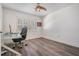 Bright office features hardwood flooring, a ceiling fan and a large window with plantation shutters at 1123 Hounds Run, Safety Harbor, FL 34695