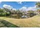 Enjoy the tranquil pond view from this beautifully landscaped backyard; a serene retreat at 1123 Hounds Run, Safety Harbor, FL 34695