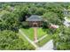 Aerial view of a brick home surrounded by lush greenery and a well-manicured lawn at 11806 Willow Point Way, Tampa, FL 33618