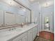 Bathroom featuring double sinks, a large mirror and natural light from a glass door at 11806 Willow Point Way, Tampa, FL 33618