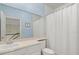 Bathroom with single sink, large mirror and a shower/tub with a curtain at 11806 Willow Point Way, Tampa, FL 33618