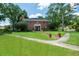 Two-story brick home with a manicured lawn and a brick walkway leading to the front door at 11806 Willow Point Way, Tampa, FL 33618