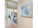 Bright hallway view with artwork, leading to a bedroom with a seating area and modern decor at 1208 E Kennedy Blvd # 1017, Tampa, FL 33602