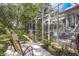 Home boasts an inviting backyard with a screened lanai, outdoor seating, and meticulously maintained landscaping at 1312 Gulf Rd, Tarpon Springs, FL 34689