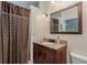 Charming bathroom featuring granite vanity, decorative fixtures, and a shower with curtain at 1312 Gulf Rd, Tarpon Springs, FL 34689