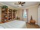 Cozy bedroom featuring built-in shelves, a ceiling fan, and a window with natural light at 1312 Gulf Rd, Tarpon Springs, FL 34689