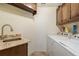 Laundry room featuring a stainless steel sink and modern washer and dryer at 1312 Gulf Rd, Tarpon Springs, FL 34689