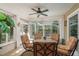 Enclosed patio featuring a ceiling fan, a glass table with seating, and views of the backyard at 1312 Gulf Rd, Tarpon Springs, FL 34689