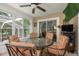 Enclosed patio featuring a ceiling fan, a glass table with seating, and views of the backyard at 1312 Gulf Rd, Tarpon Springs, FL 34689