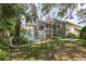 Beautiful in-ground pool with an open-air screened enclosure, accompanied by mature trees and landscaping at 1312 Gulf Rd, Tarpon Springs, FL 34689